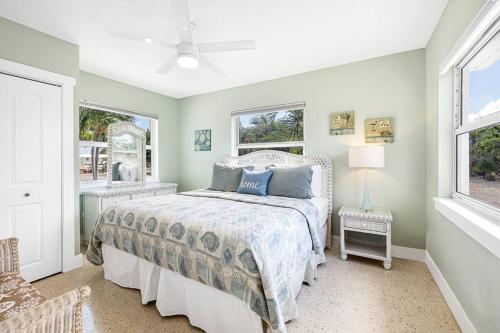 a bedroom with a bed and two windows at Super Snapper lux w/Heated Pool, Tiki, Dock, Lanai in Marathon