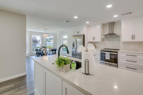 a kitchen with white cabinets and a dining room at Waterfront Hot Springs Home with Dock and Porch! in Hot Springs