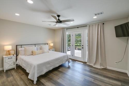 a white bedroom with a bed and a ceiling fan at Waterfront Hot Springs Home with Dock and Porch! in Hot Springs