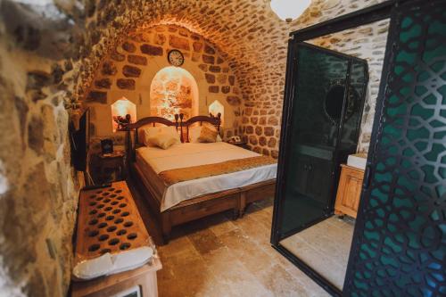 um quarto com uma cama e um espelho em Hanedan Konağı Butik Otel Deluxe Queen Bed Double Room Verdo em Mardin
