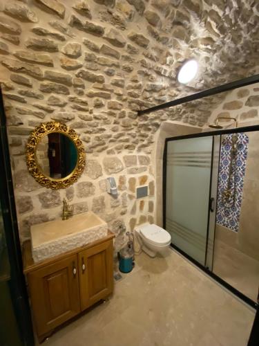 een stenen badkamer met een wastafel en een toilet bij Hanedan Konağı Butik Otel Deluxe Queen Bed Double Room Verdo in Mardin