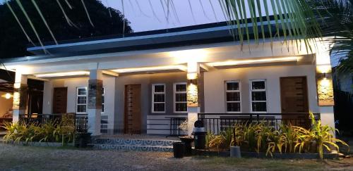 ein kleines weißes Haus mit Licht drauf in der Unterkunft RICHVILLE LITTLE BORACAY GUEST HOUSE in Calatagan