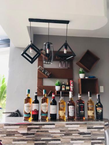 a group of bottles of alcohol sitting on a bar at RICHVILLE LITTLE BORACAY GUEST HOUSE in Calatagan