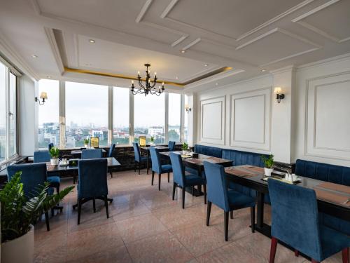 a restaurant with tables and chairs and large windows at The Flower Boutique Hotel & Travel in Hanoi