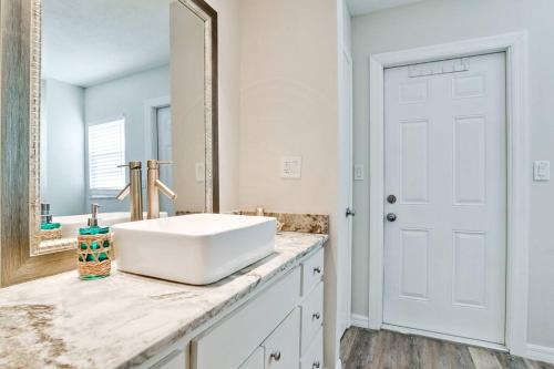 uma casa de banho branca com um lavatório e um espelho em Trendy 4-Bedroom Heated Pool Car Near Beaches em Sarasota