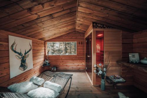 a cabin with a bed in a room with wooden walls at Wooden Nest in Durbuy