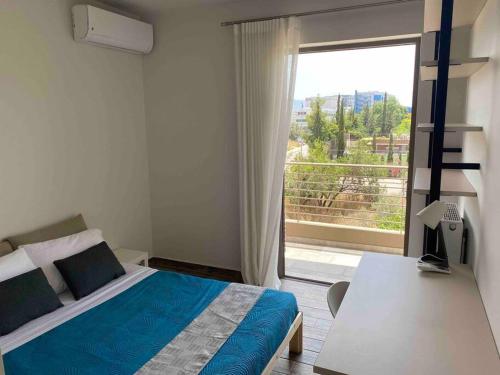 ein Schlafzimmer mit einem Bett und einem großen Fenster in der Unterkunft Dazzling and stylish 2BR Apartment in Athen