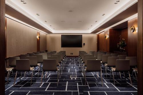 a conference room with chairs and a projection screen at The Tasman, a Luxury Collection Hotel, Hobart in Hobart