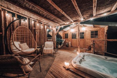 a room with a bath tub and a chair at Wooden Nest in Durbuy