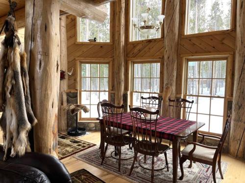 comedor con mesa y sillas en una cabaña en The Wyoming Lodge and Game Room, en Dubois