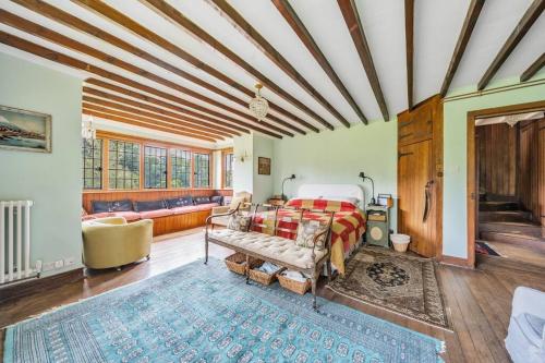 a bedroom with a bed and a couch at Amazing Arts & Crafts House in Robertsbridge