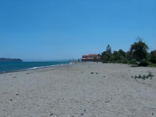a sandy beach with trees and the ocean at Gerona Mare Apartments in Gerani Chanion