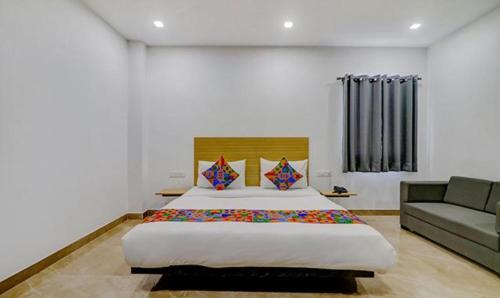 a bedroom with a large bed and a couch at FabHotel Premium Kashi in Varanasi