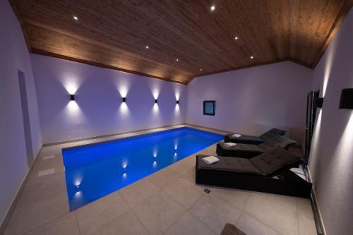 Piscina en una habitación con sofá y mesa en Eifellodge - am roten Sandberg en Prüm