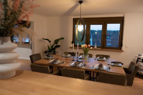 a dining room with a wooden table and chairs at Eifellodge - am roten Sandberg in Prüm