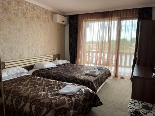 Habitación de hotel con 2 camas y ventana en Ваканционно селище Романтика en Kirkovo