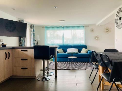 ein Wohnzimmer mit einem blauen Sofa und einem Tisch in der Unterkunft Appartement cosy entre Genève et Annecy 