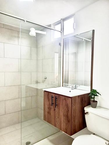 a bathroom with a sink and a shower and a toilet at HOTEL PLAYAS PERDERNALES ECUADOR in Pedernales