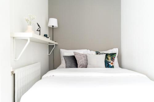 1 dormitorio con 2 camas y almohadas en Roost Laivasto 12, en Helsinki