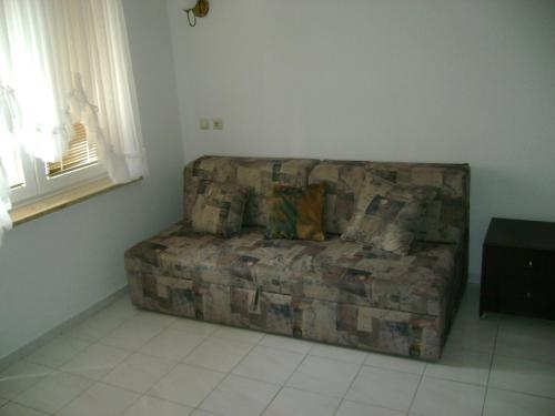 un sofá sentado en la esquina de una sala de estar en Apartments house Mai with pool Poreč, en Poreč