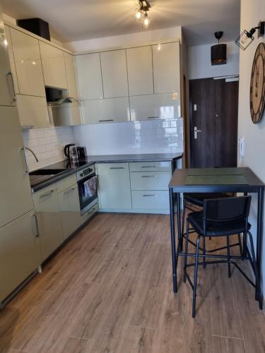 - une cuisine avec une table, une table et des chaises dans l'établissement Apartament Sky, à Leszno