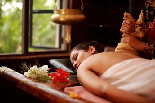 Eine Frau, die auf einem Tisch mit dem Kopf liegt. in der Unterkunft Karikkathi Beach House in Thiruvananthapuram