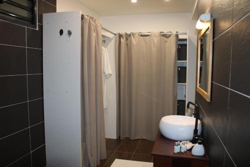 a bathroom with a white sink and a shower at Villa Perle -proche aéroport in Matoury