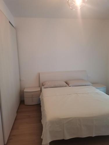 ein weißes Schlafzimmer mit einem Bett und einem Kronleuchter in der Unterkunft B&B PORTELLO Le Terrazze 2 in Mailand