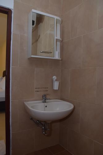 y baño con lavabo y espejo. en Kerinci Hill Holiday Home, Dago Golf (for families only), en Bandung