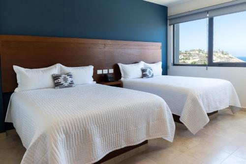 2 camas en una habitación con ventana grande en Gamma Los Cabos en San José del Cabo