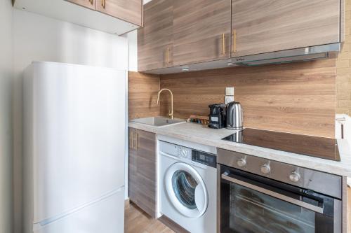La cuisine est équipée d'un lave-linge, d'un sèche-linge et d'un réfrigérateur. dans l'établissement Appartement Métro Alexandre Dumas, à Paris