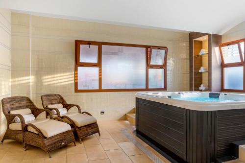 a bathroom with a large tub with wicker chairs at Royal Tenerife Country Club in San Miguel de Abona