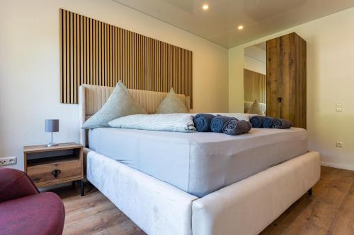 a bedroom with a large white bed with blue pillows at Moselresidenz Bellevue Alf in Alf