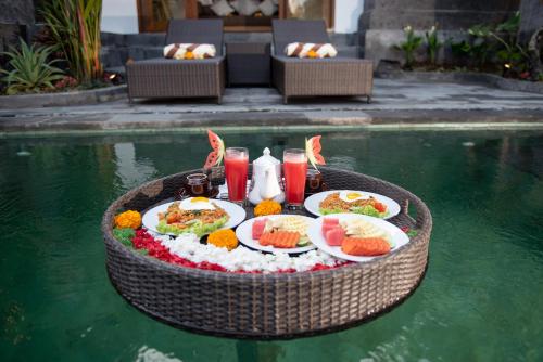 a table with food on it in the water at Madhawa Ubud Villa & Spa in Ubud