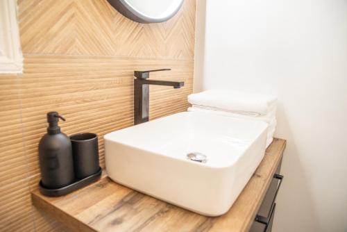 une salle de bain avec un lavabo blanc sur un comptoir en bois dans l'établissement Maison de ville solognote, à Romorantin-Lanthenay