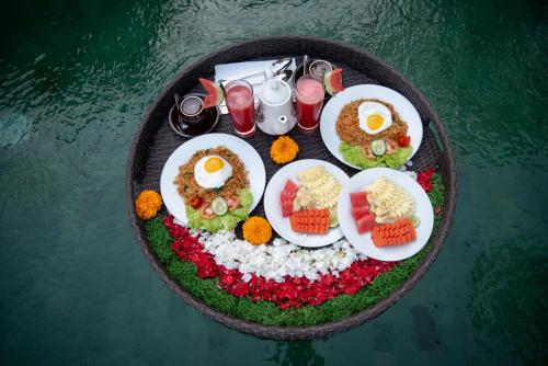 a plate of food with eggs and other foods on it at Madhawa Ubud Villa & Spa in Ubud