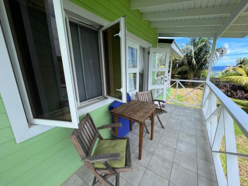 a porch with two chairs and a table at Waves Villa Guesthouse in Kingstown