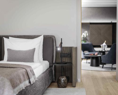 a bedroom with a bed and a living room at Hotel Weisses Roessl in Kitzbühel
