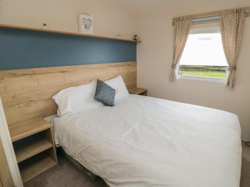a bedroom with a large white bed and a window at No30 Elm Rise in Filey