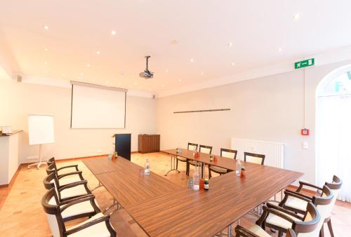 a conference room with a long table and chairs at Stadthotel Kramer in Villach