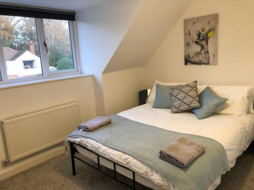 a bedroom with a bed and a window at Surrey - Private House with Garden & Parking 12 in Wentworth