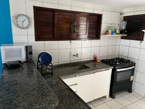 a kitchen with a sink and a stove top oven at CASA DE PRAIA PEROBA in Maragogi