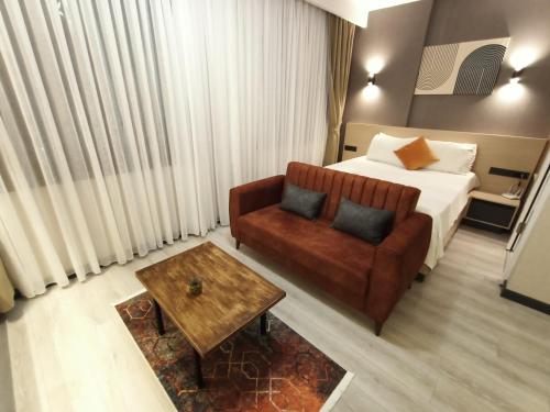 um quarto de hotel com uma cama, um sofá e uma mesa em NEW FALCON Palas OTEL em Istambul