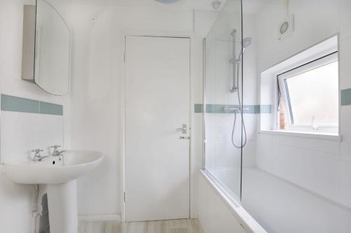 uma casa de banho branca com um lavatório e um chuveiro em Ann's Place em York