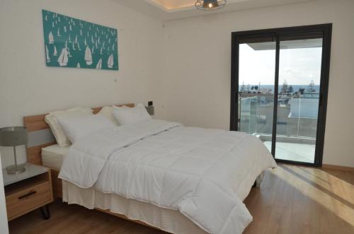 una camera bianca con un letto e una finestra di Fabulous sea view apartment a El Harhoura