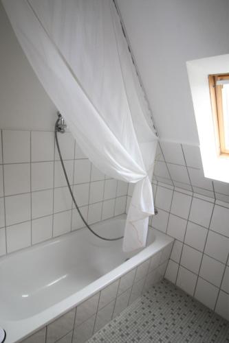 a bath tub with a shower curtain in a bathroom at Nord-Strand in Norden