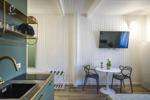 a kitchen with a table and chairs in a room at Siculea Home in Adrano