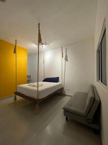プエルト・モレロスにあるR Las chulasのベッドルーム(四柱式ベッド1台、椅子付)