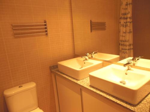 a bathroom with two sinks and a toilet at Apartamentos Grifo Vacances Julia in El Tarter