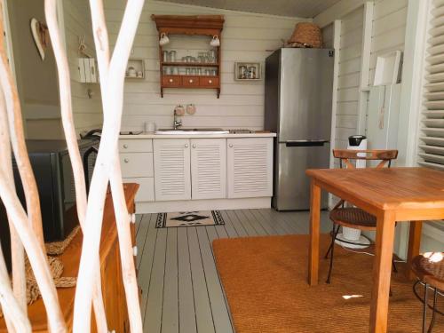 a kitchen with a stainless steel refrigerator and a table at Les Gîtes de Bergette in Petit-Bourg